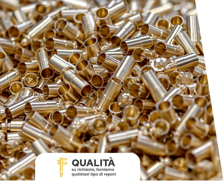 Boccole e spine tornite in ottone impilate, pronte per i controlli dimensionali e superficiali nella sala metrologica del reparto torneria.